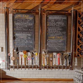Hanging beer towers hanging from the ceiling with draft taps.