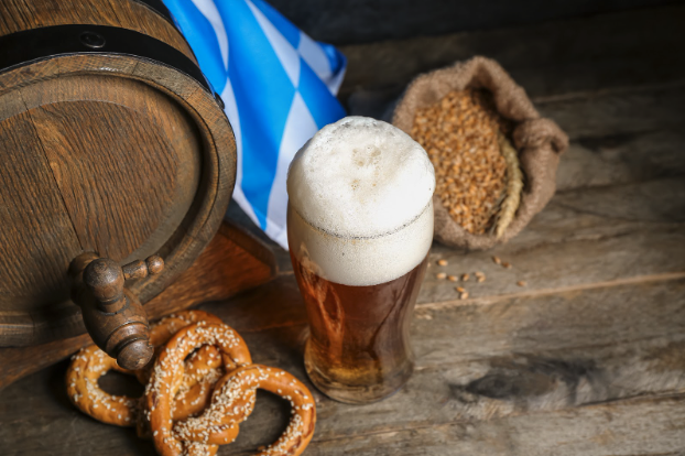 A spread of draft beer, pretzels and bavarian flags, describing what is Oktoberfest.