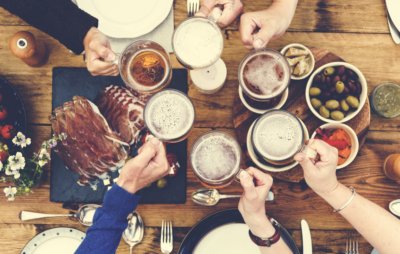 A group of people raising a toast with holiday beer.