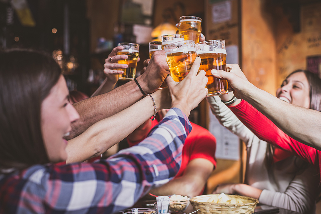 A group of young adults cheersing their draft beers. 2025 beer trends